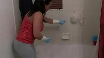 A senhora faz um show para limpar a banheira.