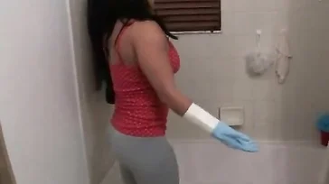 A senhora faz um show para limpar a banheira.