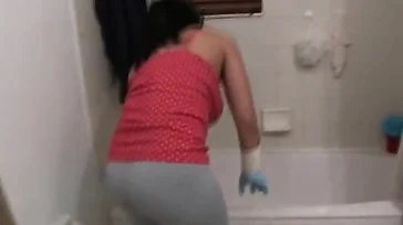 A senhora faz um show para limpar a banheira.